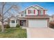 Charming two-story home featuring stone accents, gray siding, red shutters, and a well-maintained front yard at 23955 Glenmoor Way, Parker, CO 80138