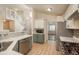 Well-lit kitchen with stainless appliances, gray cabinets, and adjacent staircase at 23955 Glenmoor Way, Parker, CO 80138