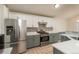 Well-equipped kitchen with stainless steel refrigerator, gas range, and white cabinets at 23955 Glenmoor Way, Parker, CO 80138