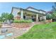 Expansive backyard with a covered patio, hot tub, stone pathway, and lush greenery at 7949 S Blackstone Pkwy, Aurora, CO 80016