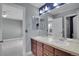 Bright bathroom featuring double sink vanity with cabinets and a connecting bedroom with light gray walls at 7949 S Blackstone Pkwy, Aurora, CO 80016