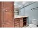Neutral bathroom with wooden cabinets and drawers, tile countertops, and a large mirror at 7949 S Blackstone Pkwy, Aurora, CO 80016