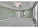 Expansive bedroom boasts tray ceilings, a ceiling fan, neutral carpet, and multiple entry points at 7949 S Blackstone Pkwy, Aurora, CO 80016