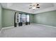 Spacious bedroom boasts tray ceilings, a ceiling fan, neutral carpet, and large windows providing ample natural light at 7949 S Blackstone Pkwy, Aurora, CO 80016