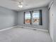 Bright bedroom with neutral carpet and two windows offering natural light and neighborhood views at 7949 S Blackstone Pkwy, Aurora, CO 80016
