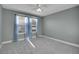 Serene bedroom featuring soft blue curtains and plush carpet, with ample natural light streaming through the windows at 7949 S Blackstone Pkwy, Aurora, CO 80016