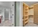 Open walk-in closet provides ample storage with custom wood shelving, enhancing organization and accessibility at 7949 S Blackstone Pkwy, Aurora, CO 80016