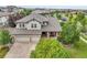 A beautiful home with a three-car garage surrounded by lush trees and a well-maintained lawn at 7949 S Blackstone Pkwy, Aurora, CO 80016