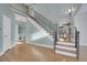 Foyer featuring light hardwood flooring, stairway with iron railing, and views of the living room and kitchen at 7949 S Blackstone Pkwy, Aurora, CO 80016