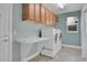 Laundry room featuring tile floors, modern washer and dryer, and overhead cabinet storage at 7949 S Blackstone Pkwy, Aurora, CO 80016