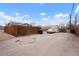Gravel backyard area with a parking space, fence and shed at 3390 S Elm St, Denver, CO 80222