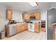 Functional kitchen featuring wood cabinets, white appliances, and neutral tile flooring at 3390 S Elm St, Denver, CO 80222