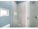 A well-lit shower stall featuring light gray tiled walls and glass doors at 4144 Tennyson St # 10, Denver, CO 80212