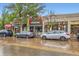 Street view of commercial buildings and storefronts with parked cars on a wet street at 4144 Tennyson St # 10, Denver, CO 80212