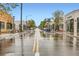 Scenic street view featuring storefronts and lush trees on a wet day, with yellow lines on the road at 4144 Tennyson St # 10, Denver, CO 80212