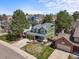 Aerial view of a charming two-story green home with well-maintained landscaping and a three car garage at 9408 Harvard Dr, Highlands Ranch, CO 80130