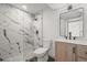 Modern bathroom with marble tile shower, mosaic tile floor, and vanity with wood cabinet at 9408 Harvard Dr, Highlands Ranch, CO 80130