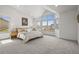 A light-filled bedroom with high ceilings, neutral colors, and large windows offering neighborhood views at 9408 Harvard Dr, Highlands Ranch, CO 80130