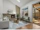 Bright living room with a brick fireplace, wooden floors and large windows overlooking the deck at 9408 Harvard Dr, Highlands Ranch, CO 80130