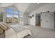 A bright main bedroom features large windows and light tones, with a sliding door to the main bathroom at 9408 Harvard Dr, Highlands Ranch, CO 80130