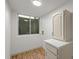 Utility room with wood-look flooring, window, and white storage cabinet at 9408 Harvard Dr, Highlands Ranch, CO 80130