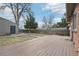 Expansive backyard showing a wooden deck, gray garage, mature trees, and well-maintained lawn at 1632 S Josephine St, Denver, CO 80210