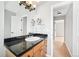Bathroom vanity featuring a black countertop, wood cabinets, and a large mirror at 1632 S Josephine St, Denver, CO 80210