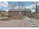 Charming brick home with landscaped front yard and concrete steps leading to the entrance at 1632 S Josephine St, Denver, CO 80210