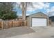 Exterior of detached garage with white door and gray finish siding next to a wooden fence at 1632 S Josephine St, Denver, CO 80210