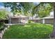 Fenced-in backyard with a covered patio, fire pit, a lawn and a shed in the background at 3061 S Marion St, Englewood, CO 80113