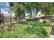 Large backyard featuring a mature tree, a fire pit and a gardening enclosure at 3061 S Marion St, Englewood, CO 80113