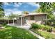 Beautiful backyard featuring a covered patio, lawn, garden area, and a well-maintained exterior at 3061 S Marion St, Englewood, CO 80113