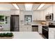 Bright kitchen features a stainless steel refrigerator, black window trim, and quartz countertops at 3061 S Marion St, Englewood, CO 80113