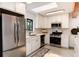 Modern kitchen with stainless steel appliances, white cabinetry, and natural light from window at 3061 S Marion St, Englewood, CO 80113