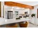 Updated kitchen with stainless steel appliances, white cabinetry, breakfast bar, and quartz countertops at 3061 S Marion St, Englewood, CO 80113