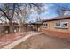 A spacious brick patio enhances the backyard, framed by mature trees and a lawn at 2259 Meade St, Denver, CO 80211