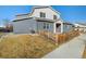 Attractive two-story home showcases a red front door, well-kept lawn and a charming wooden fence at 6111 W 28Th Ct, Wheat Ridge, CO 80214