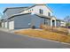 Modern home featuring a two-car garage, stylish siding, neat landscaping, and a charming wooden fence at 6111 W 28Th Ct, Wheat Ridge, CO 80214