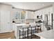 Modern kitchen featuring stainless steel appliances, white cabinetry, and a center island with seating at 6111 W 28Th Ct, Wheat Ridge, CO 80214