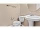 Bright bathroom featuring a white toilet, sink, faucet, towel rack and neutral wall paint at 15945 E Geddes Dr # 54, Aurora, CO 80016