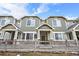 Green-sided townhome with a front porch and small yard at 15945 E Geddes Dr # 54, Aurora, CO 80016