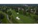 Aerial view of a lush green golf course with mature trees, sand traps, and a small meandering stream at 5747 S Lowell Blvd, Littleton, CO 80123