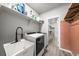 Functional laundry room with a utility sink, modern washer and dryer, and plenty of storage shelves at 14632 Longhorn Dr, Mead, CO 80542