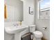 Clean half bathroom with pedestal sink, modern fixtures, and neutral decor at 10051 Belvedere Cir, Lone Tree, CO 80124