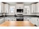Modern kitchen featuring white cabinets, granite countertops, stainless steel appliances and stylish backsplash at 10051 Belvedere Cir, Lone Tree, CO 80124