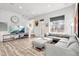Sunlit living room featuring a large gray sectional sofa, wood floors, and a view of the neighborhood at 10051 Belvedere Cir, Lone Tree, CO 80124