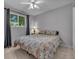 Bright bedroom featuring a ceiling fan, a large window, and comfortable bedding at 10869 W 65Th Way, Arvada, CO 80004