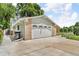 Attached garage with a four-panel door, brick facade, and paved driveway on a sunny day at 10869 W 65Th Way, Arvada, CO 80004