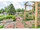 Charming garden with raised beds, stone pathways, and a wooden trellis at 10869 W 65Th Way, Arvada, CO 80004