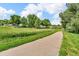 Cement walking path with grassy areas beside it and trees in the background on a sunny day at 10869 W 65Th Way, Arvada, CO 80004